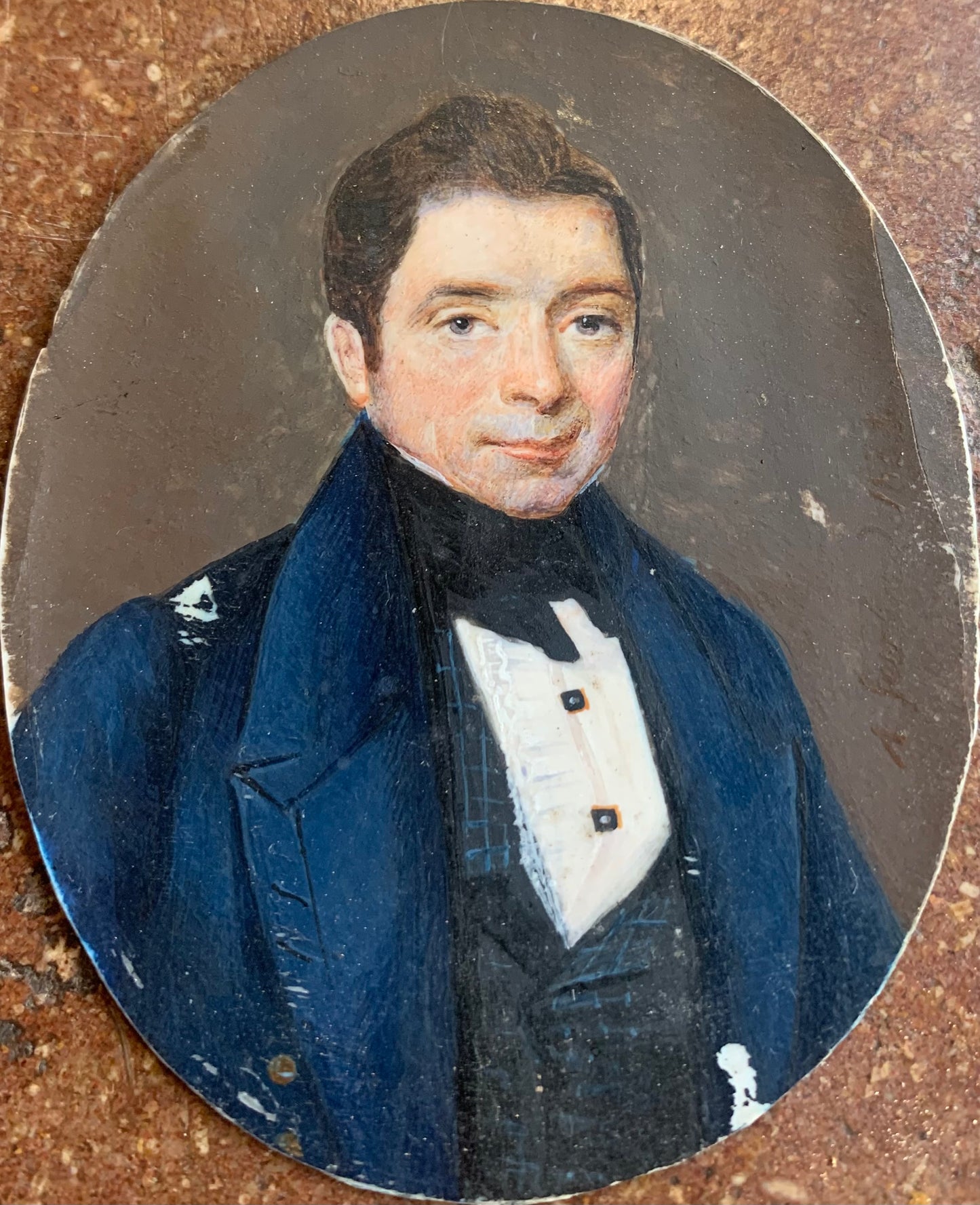 A miniature portrait of an elegant man in a black tie and pleated shirt with jewel buttons, dated 1833.