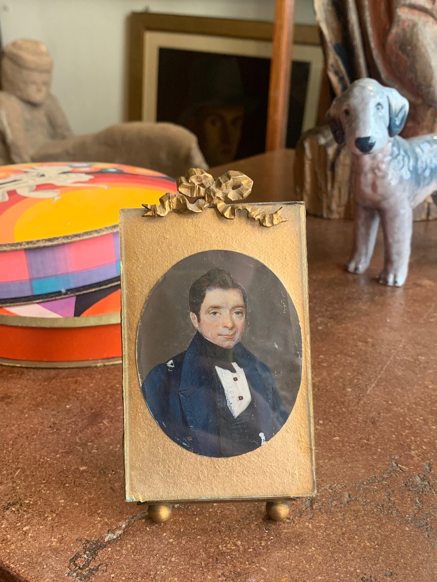 A miniature portrait of an elegant man in a black tie and pleated shirt with jewel buttons, dated 1833.