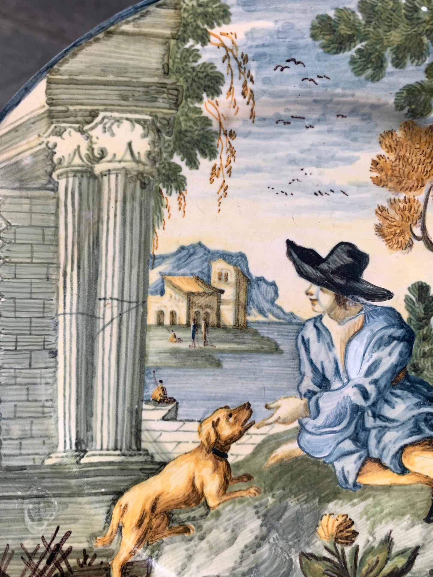 Castelli maiolica dish with young man in black hat, dog and classical ruins, mid-18th century