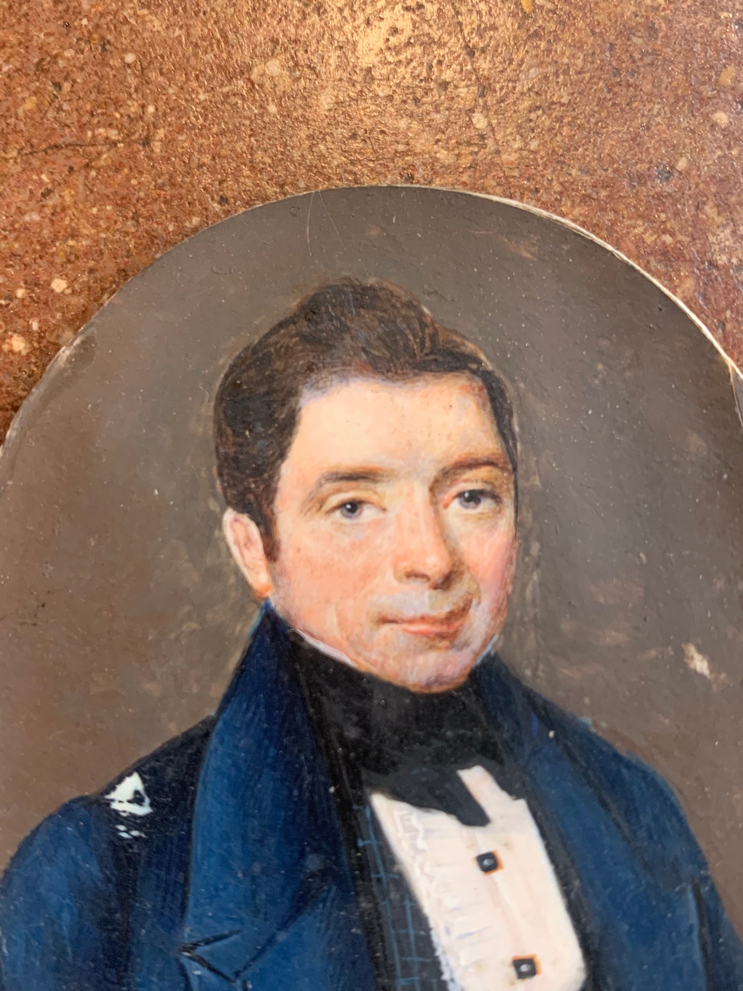 A miniature portrait of an elegant man in a black tie and pleated shirt with jewel buttons, dated 1833.