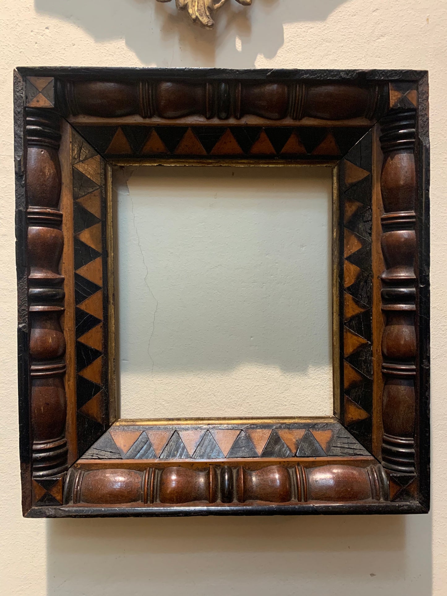Unusual frame in various woods with geometric decorations.  Early 19 century