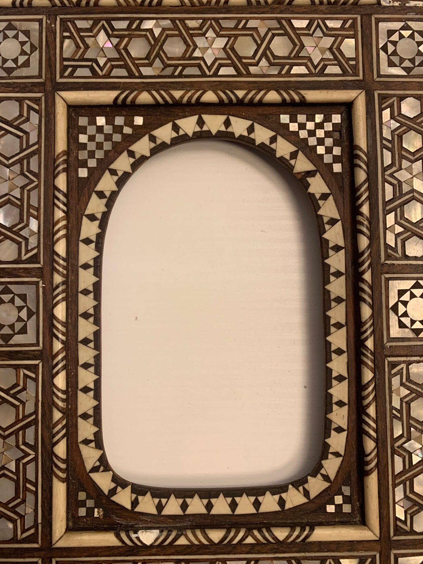 Oriental style frame with mother-of-pearl marquetry.